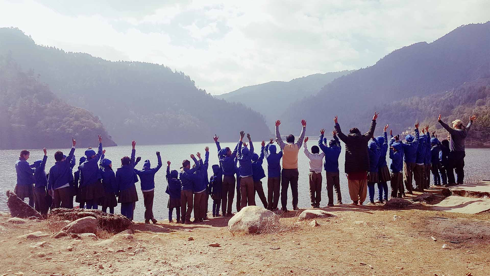 Groupfoto of the students of the school. Standing right besides a lake